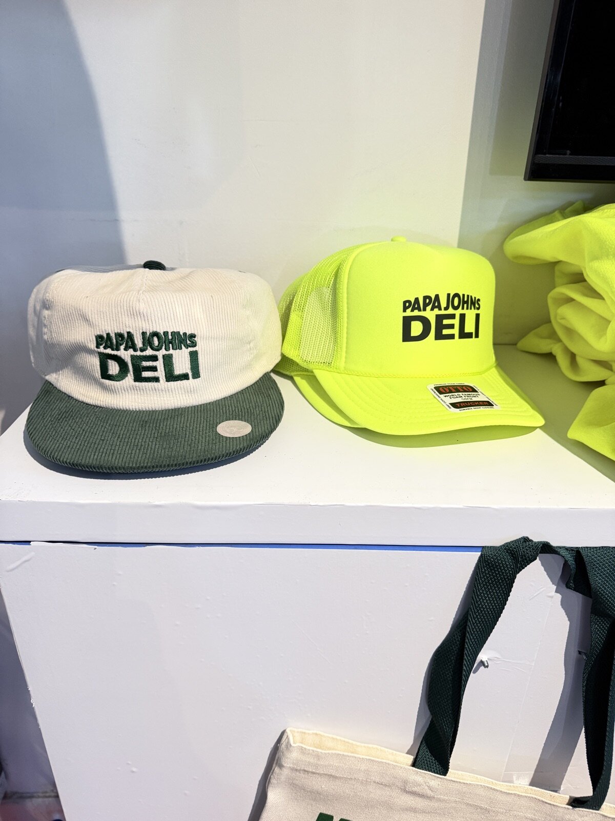 Finished embroidered caps lined up on a display at a Merch Troop event